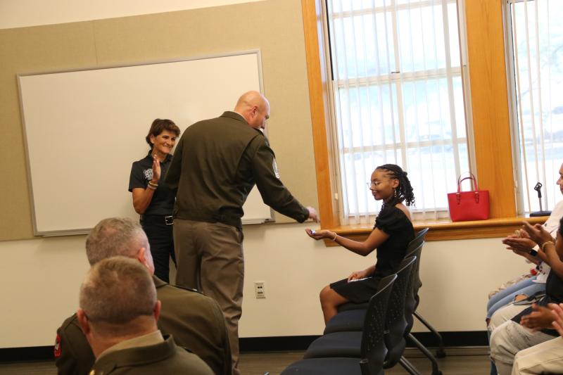 1st Sgt. Clinton Vervoren with Wisconsin National Guard presents military ID tags to Laya Jackson  