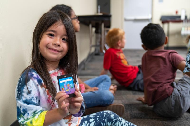 Photo of young girl holding her Mesa Library card 