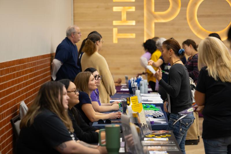 People at information tables at Domestic Violence Awareness Night at The Post in downtown Mesa
